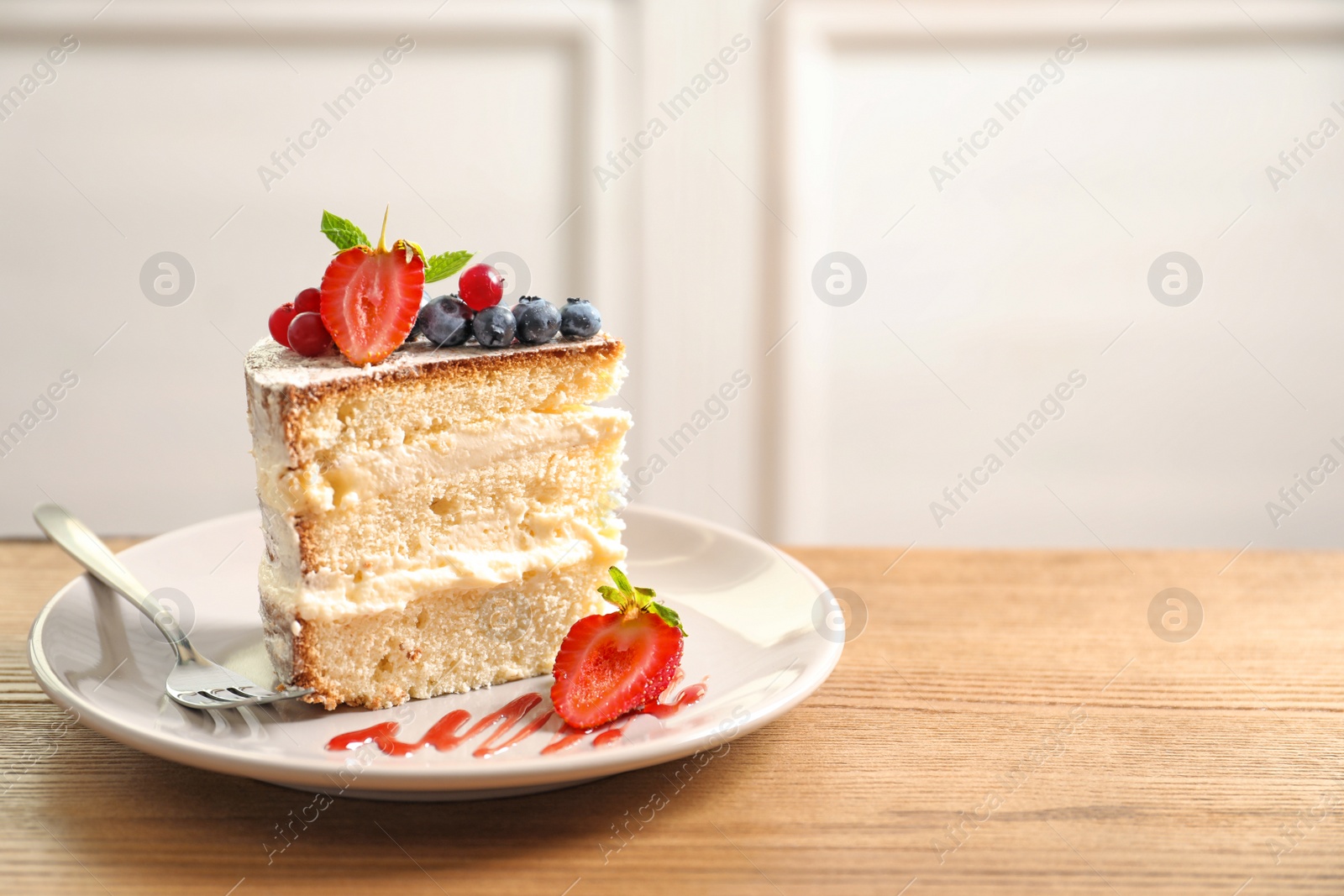 Photo of Piece of delicious homemade cake with fresh berries and space for text on blurred background