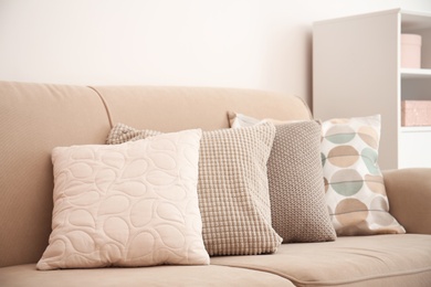 Photo of Different soft pillows on sofa in room