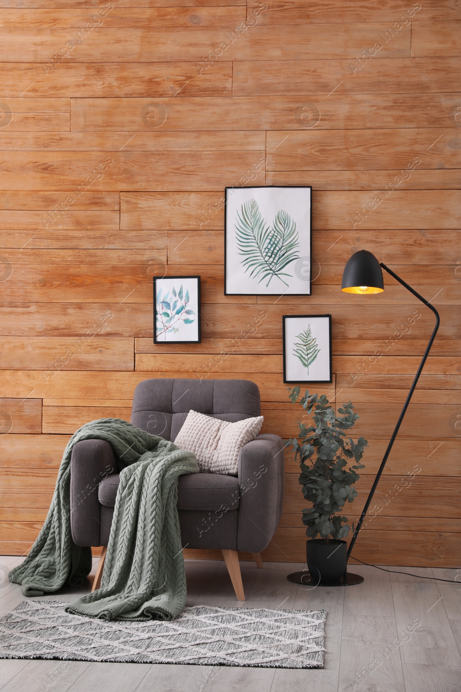 Photo of Stylish room interior with floor lamp, beautiful paintings and potted eucalyptus plant