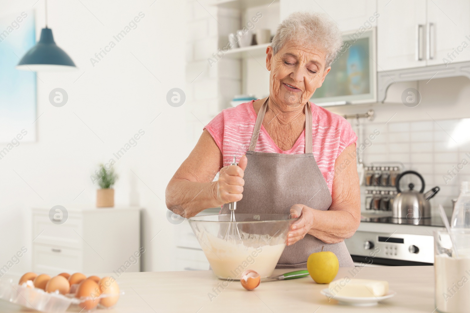 Photo of Portrait of beautiful grandmother cooking in kitchen