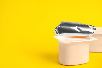 Photo of Tasty organic yogurt on yellow background. Space for text