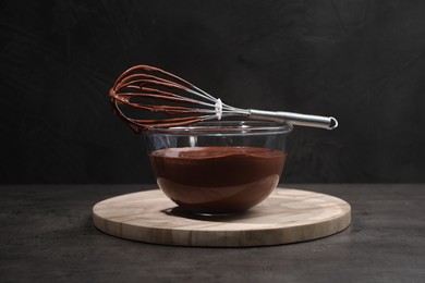 Photo of Bowl of chocolate cream and whisk on gray table
