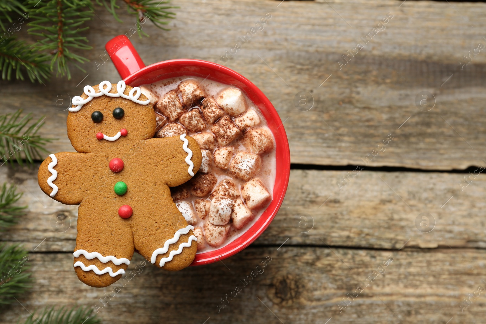 Photo of Tasty Christmas cookie in shape of man and cocoa with marshmallows on wooden table, flat lay. Space for text