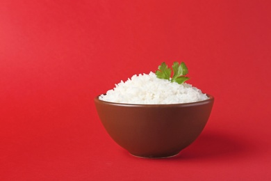 Photo of Bowl of boiled rice on color background