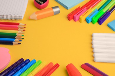 Frame made of different school stationery on yellow background, closeup and space for text. Back to school