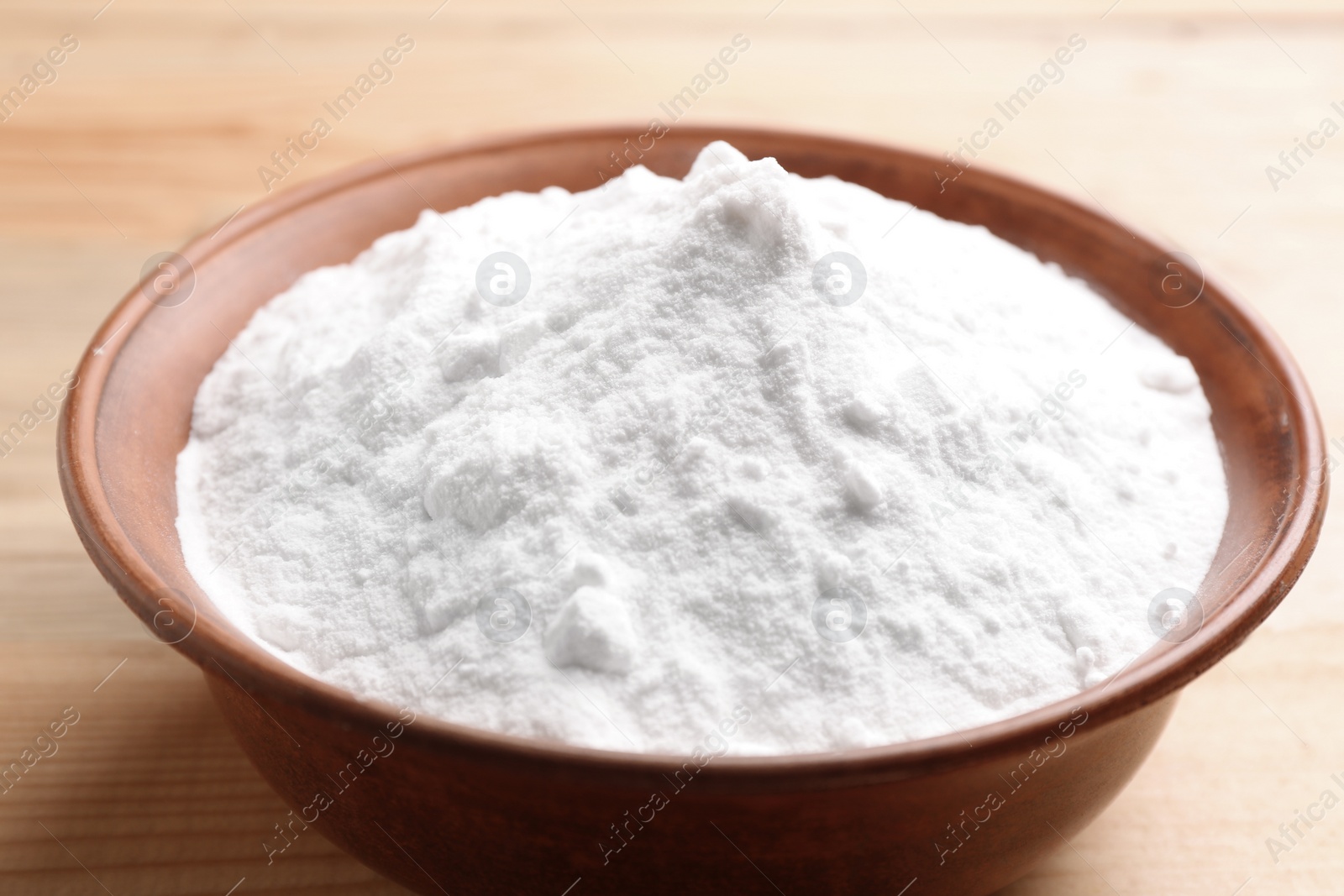 Photo of Bowl with baking soda on wooden table