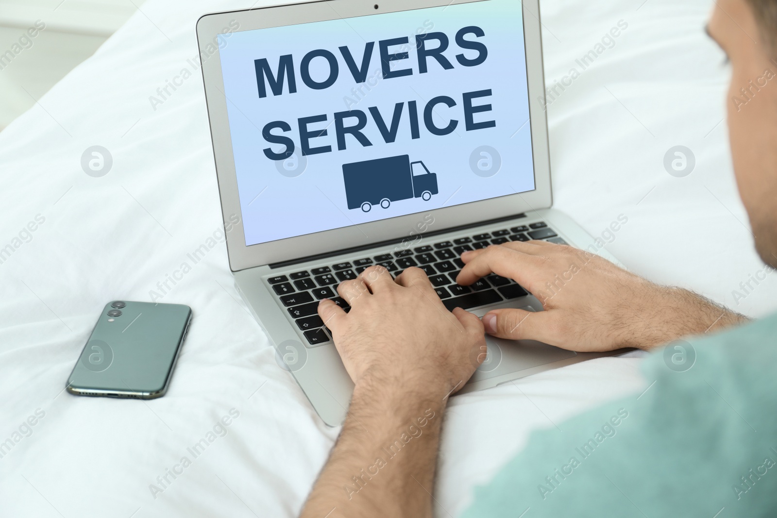 Image of Man using laptop to order movers service at home, closeup