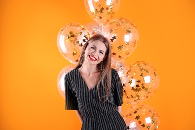 Photo of Young woman with air balloons on color background