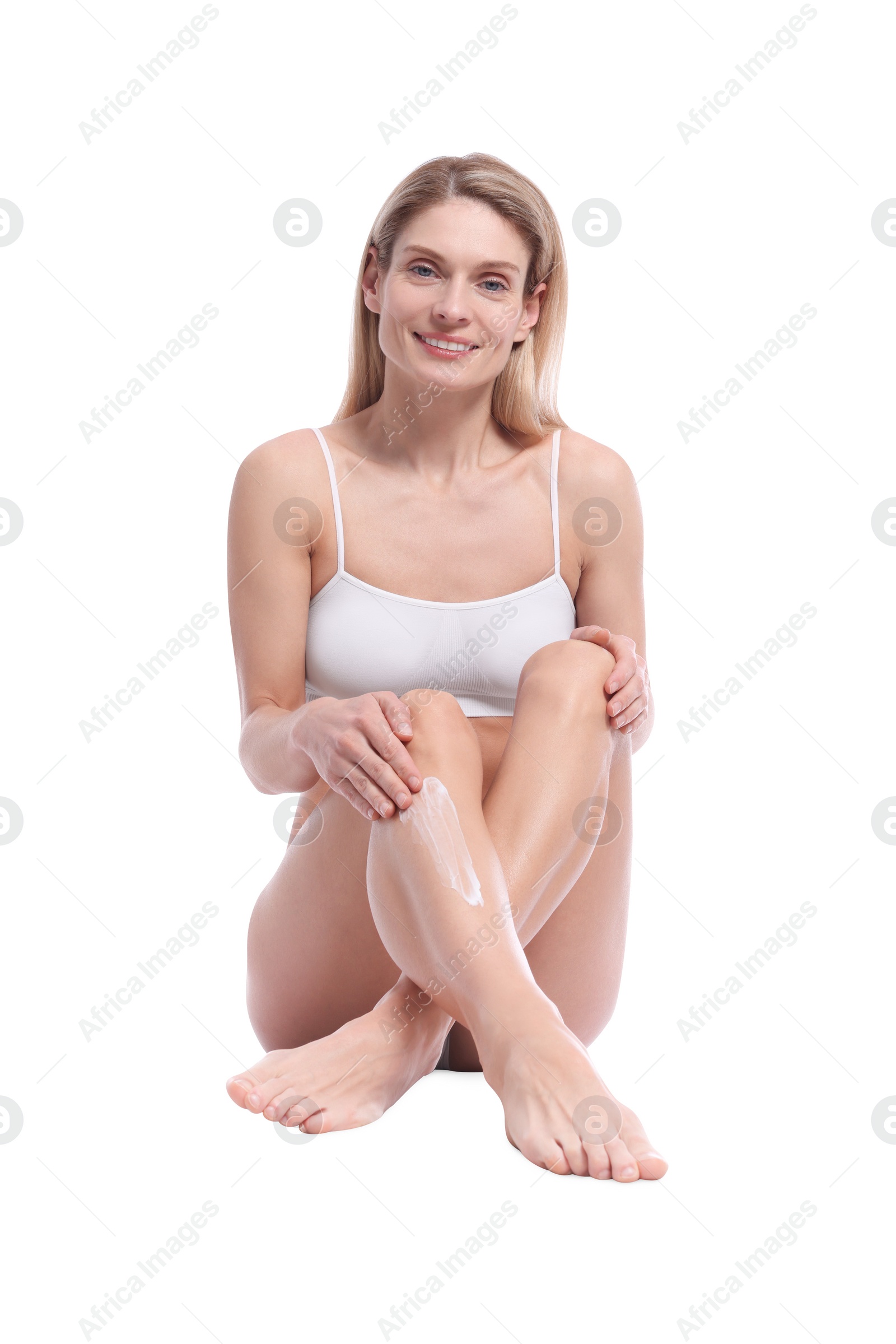 Photo of Woman applying body cream onto her leg against white background