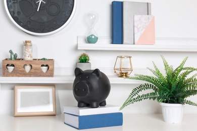 Photo of Color piggy bank on table in room. Cute interior element