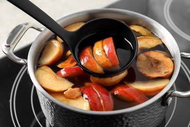 Preparing delicious compot from apple slices on stove, closeup