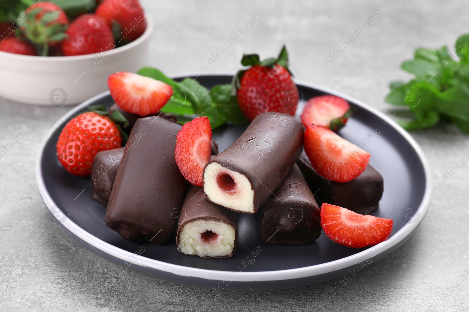 Photo of Delicious glazed curd snacks with fresh strawberries and mint on light grey table