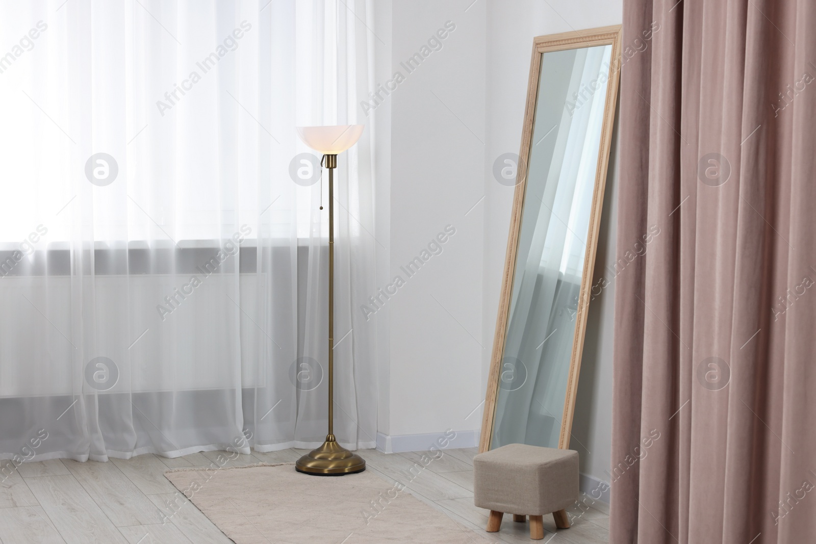 Photo of Stylish makeup room interior with long mirror and lamp