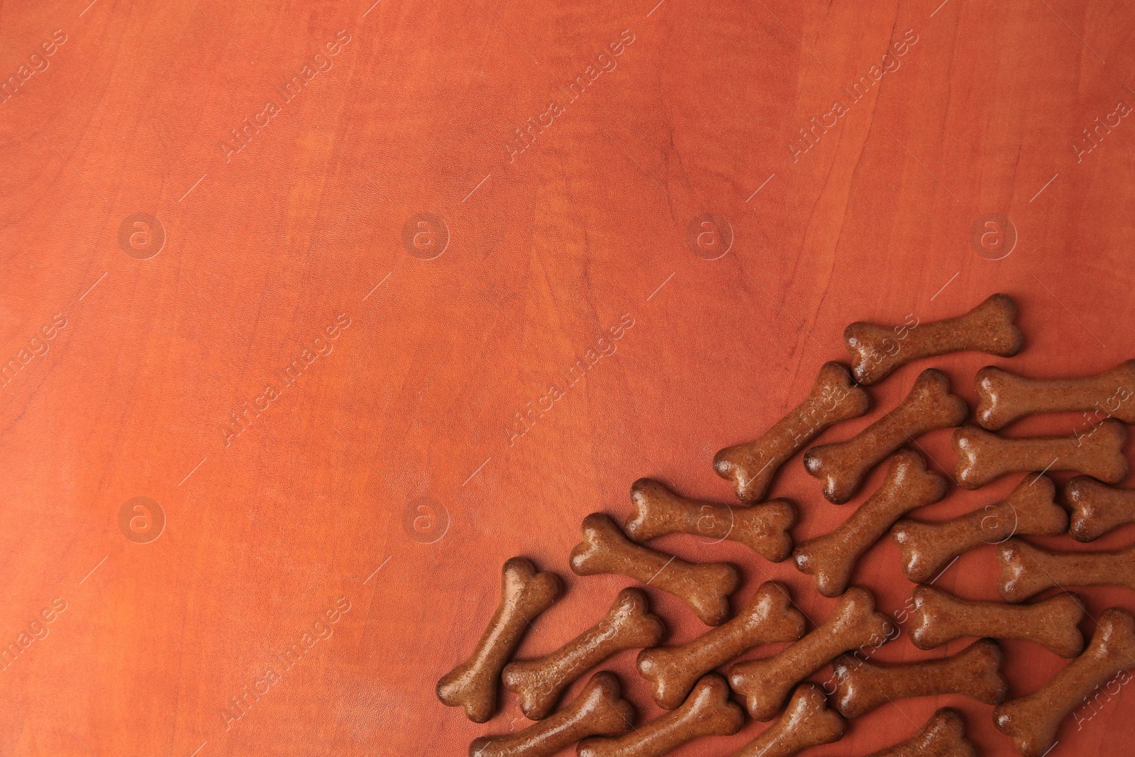 Photo of Bone shaped dog cookies on wooden background, flat lay. Space for text