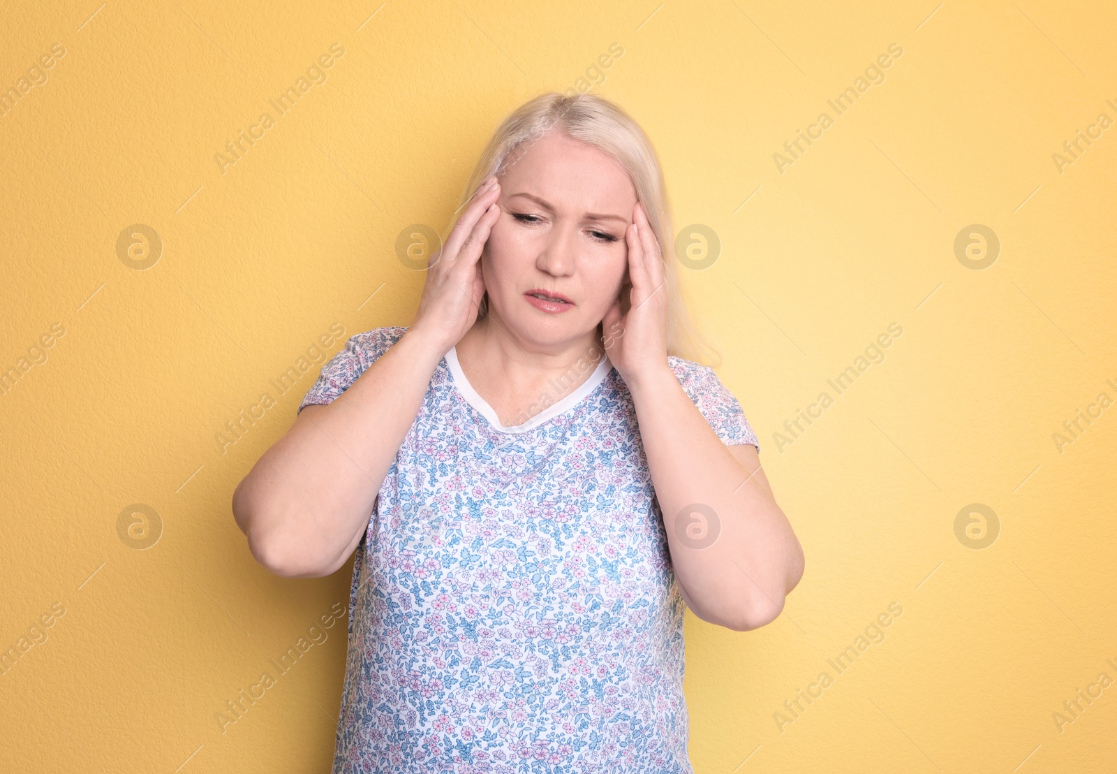 Photo of Mature woman suffering from headache on color background