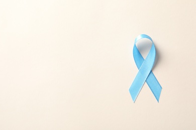 Blue ribbon on color background, top view. Cancer awareness