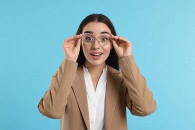 Photo of Surprised woman wearing glasses on turquoise background