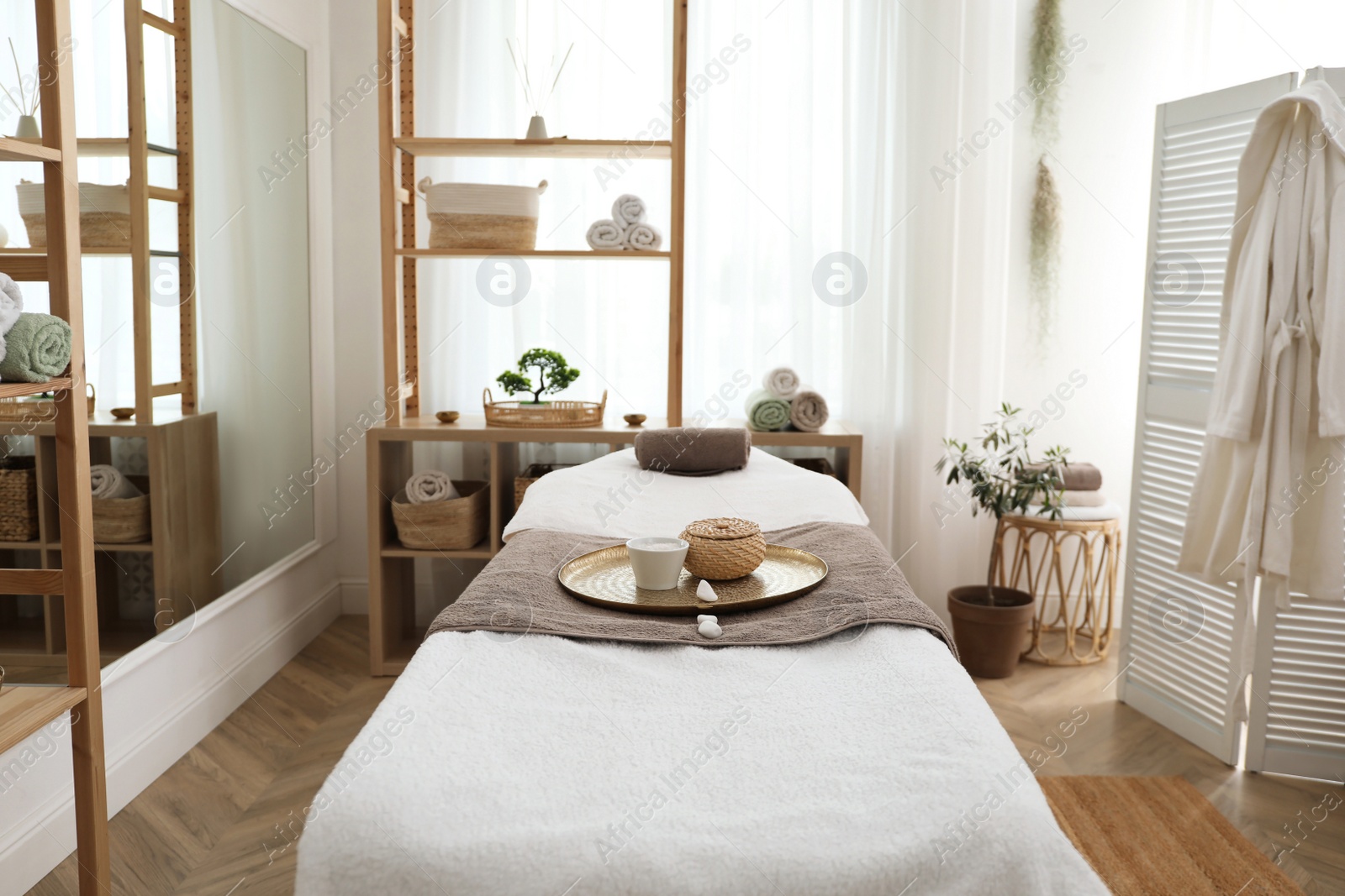 Photo of Stylish room interior with massage table in spa salon