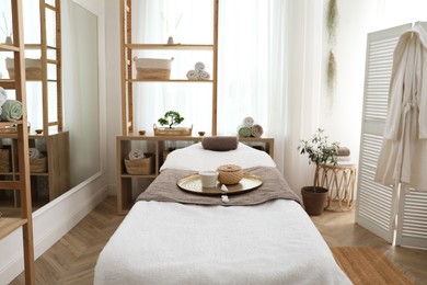 Stylish room interior with massage table in spa salon