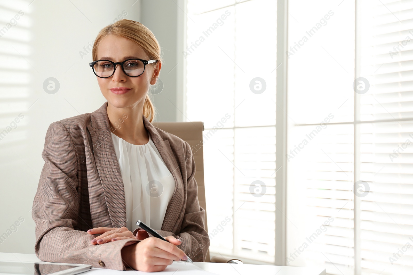 Photo of Young businesswoman sitting at table in office