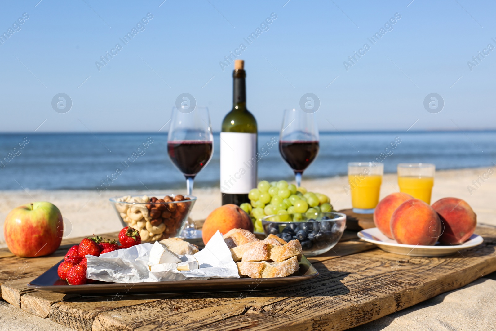 Photo of Food and drinks on beach. Summer picnic