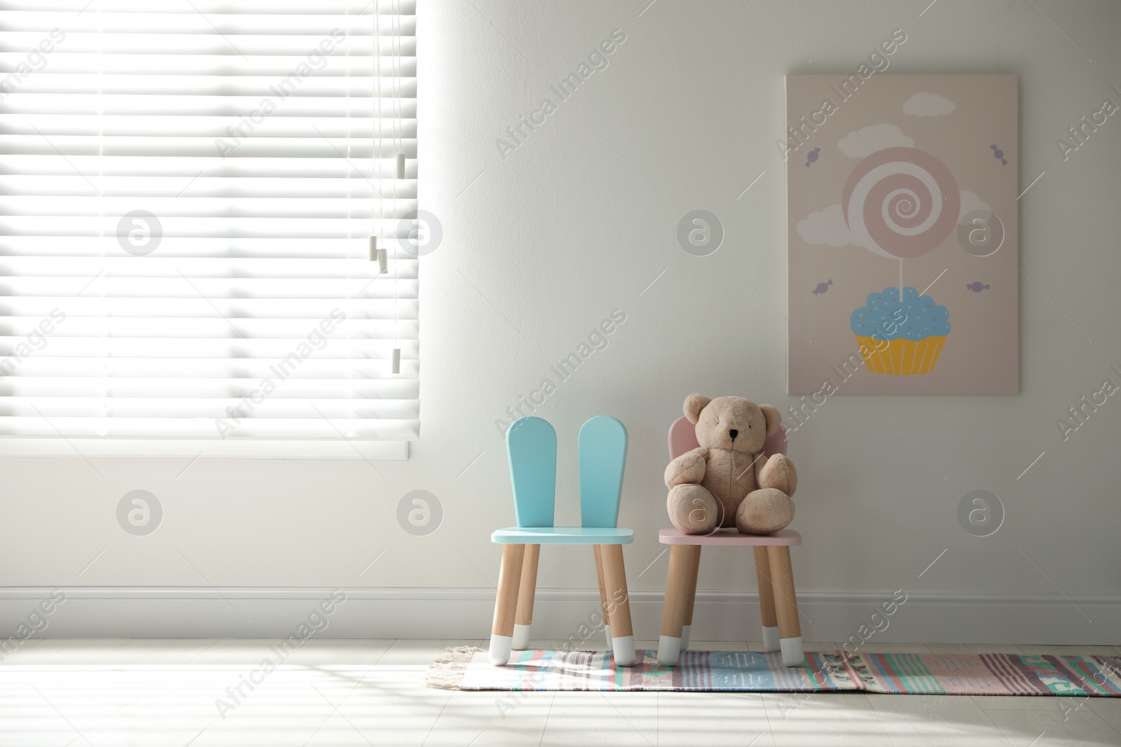 Photo of Cute chairs with bunny ears in children's room interior