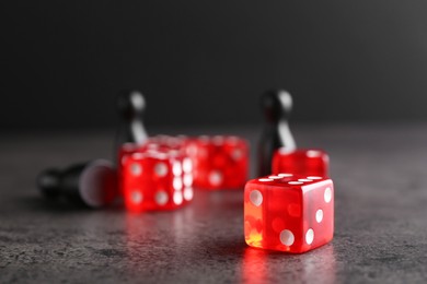 Photo of Many red game dices on grey textured table, closeup