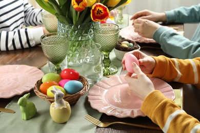 Festive table setting. Women celebrating Easter at home, closeup