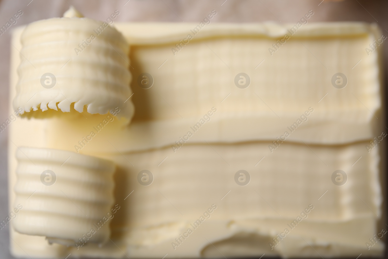 Photo of Tasty butter and curls on table, top view