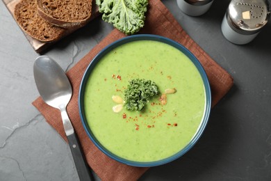 Photo of Tasty kale soup served on grey table, flat lay