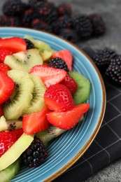 Plate of delicious fresh fruit salad on table, closeup