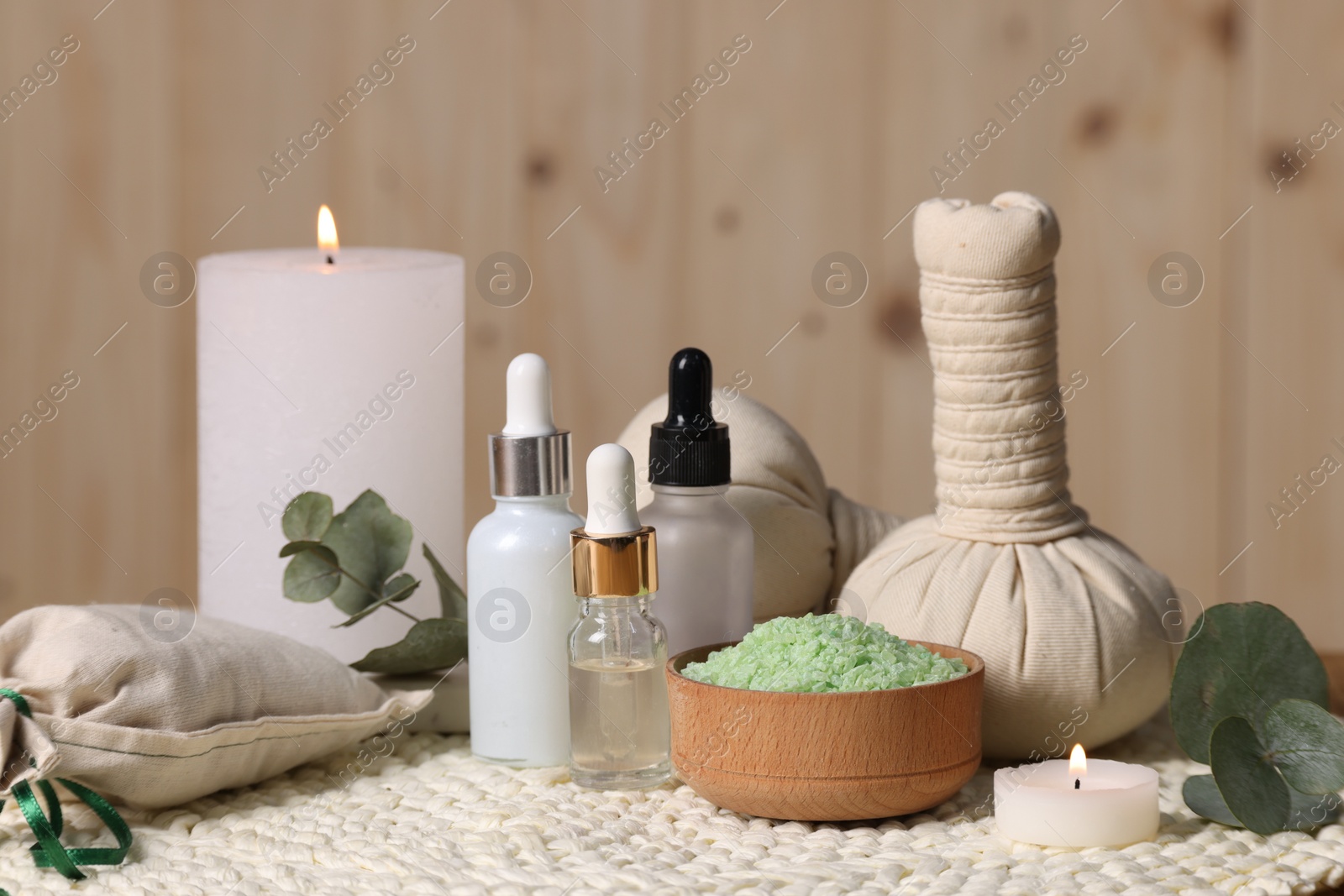 Photo of Different aromatherapy products, burning candles and eucalyptus leaves on table