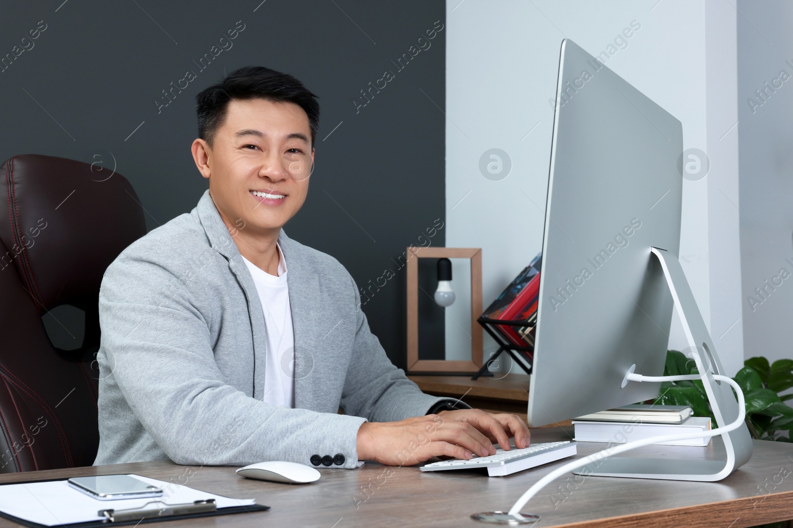 Photo of Happy successful boss working in his office