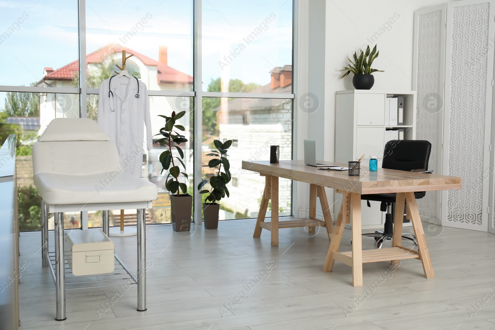 Photo of Modern medical office interior with doctor's workplace near window