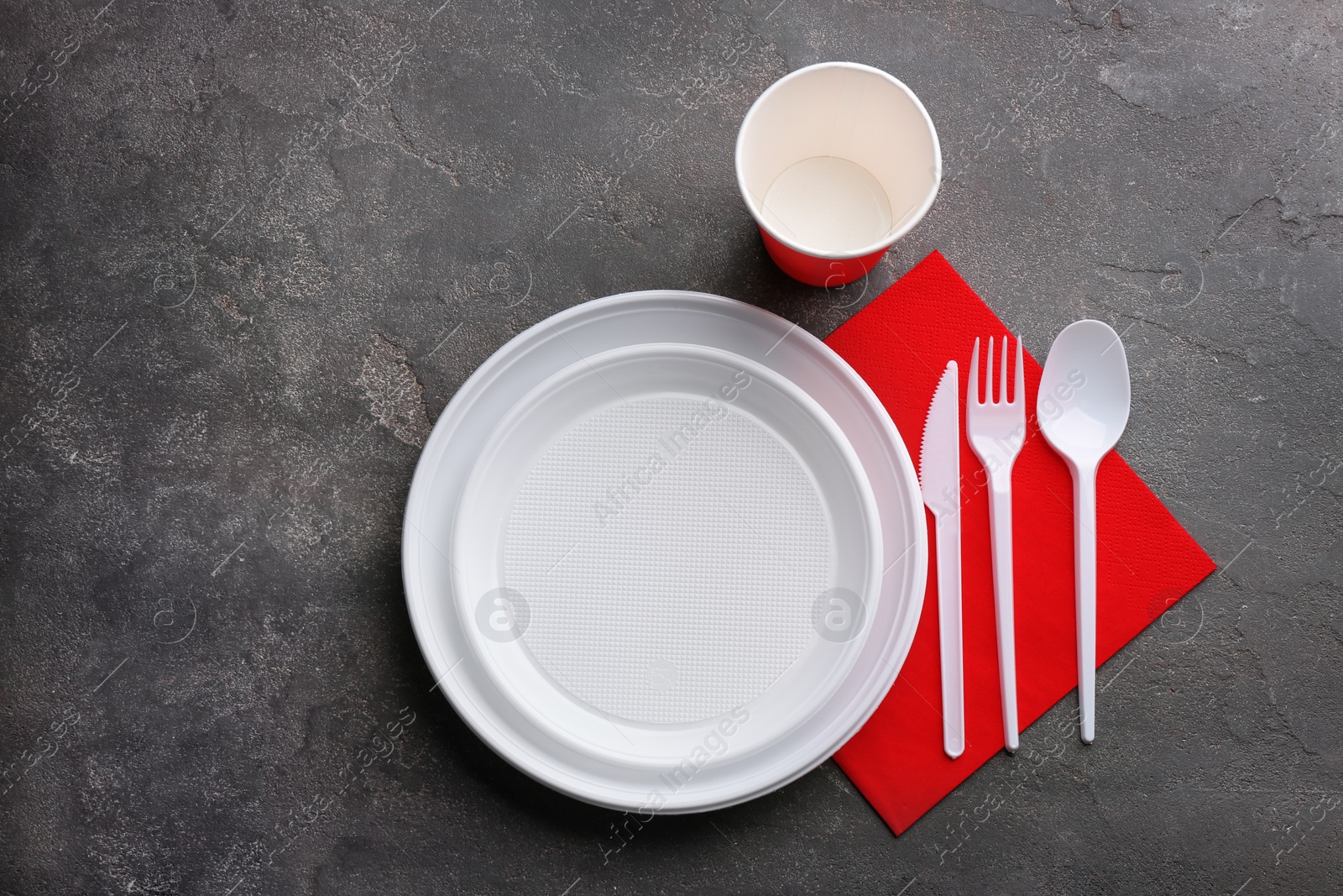 Photo of Composition with plastic dishware on grey background, flat lay. Picnic table setting