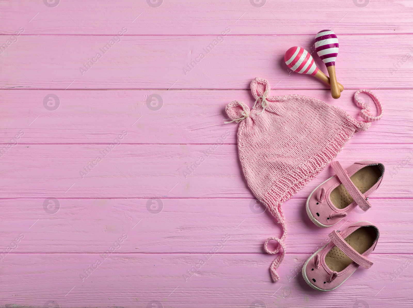 Photo of Flat lay composition with cap and space for text on wooden background. Baby accessories