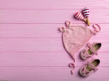 Photo of Flat lay composition with cap and space for text on wooden background. Baby accessories