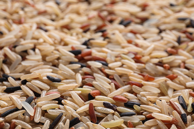 Mix of different brown rice as background, closeup