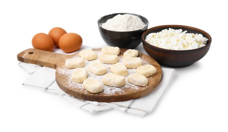 Photo of Making lazy dumplings. Wooden board with cut dough and ingredients isolated on white