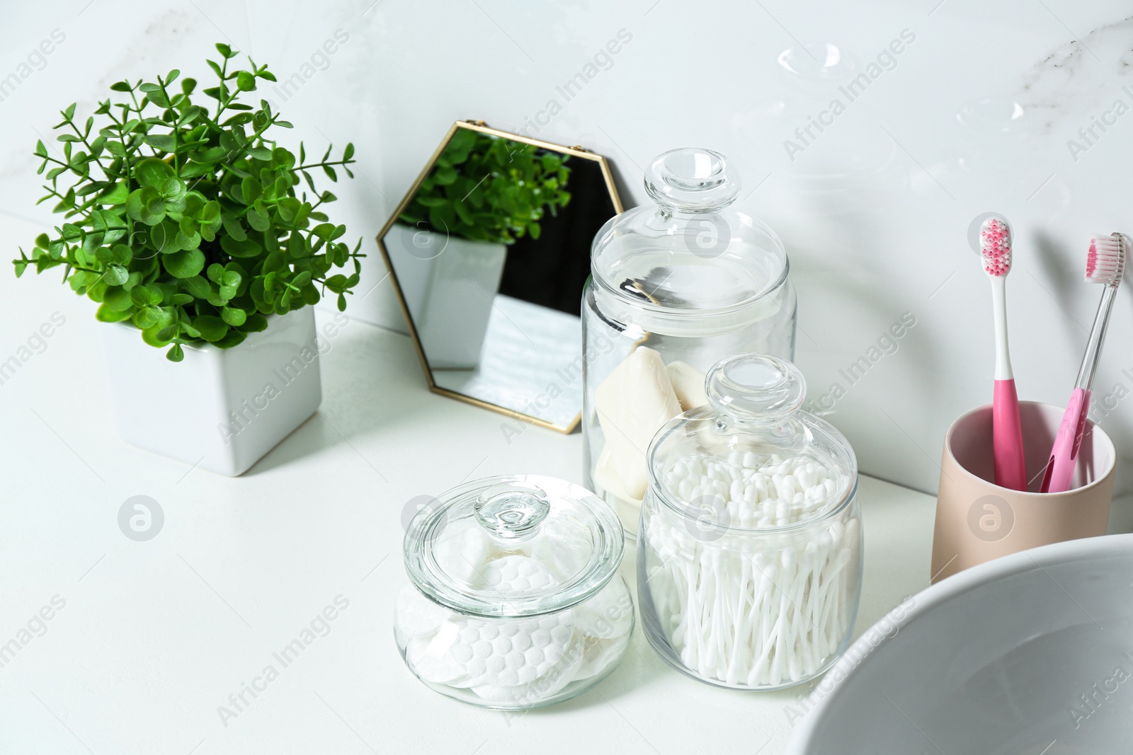 Photo of Composition with cotton pads and swabs on white countertop in bathroom