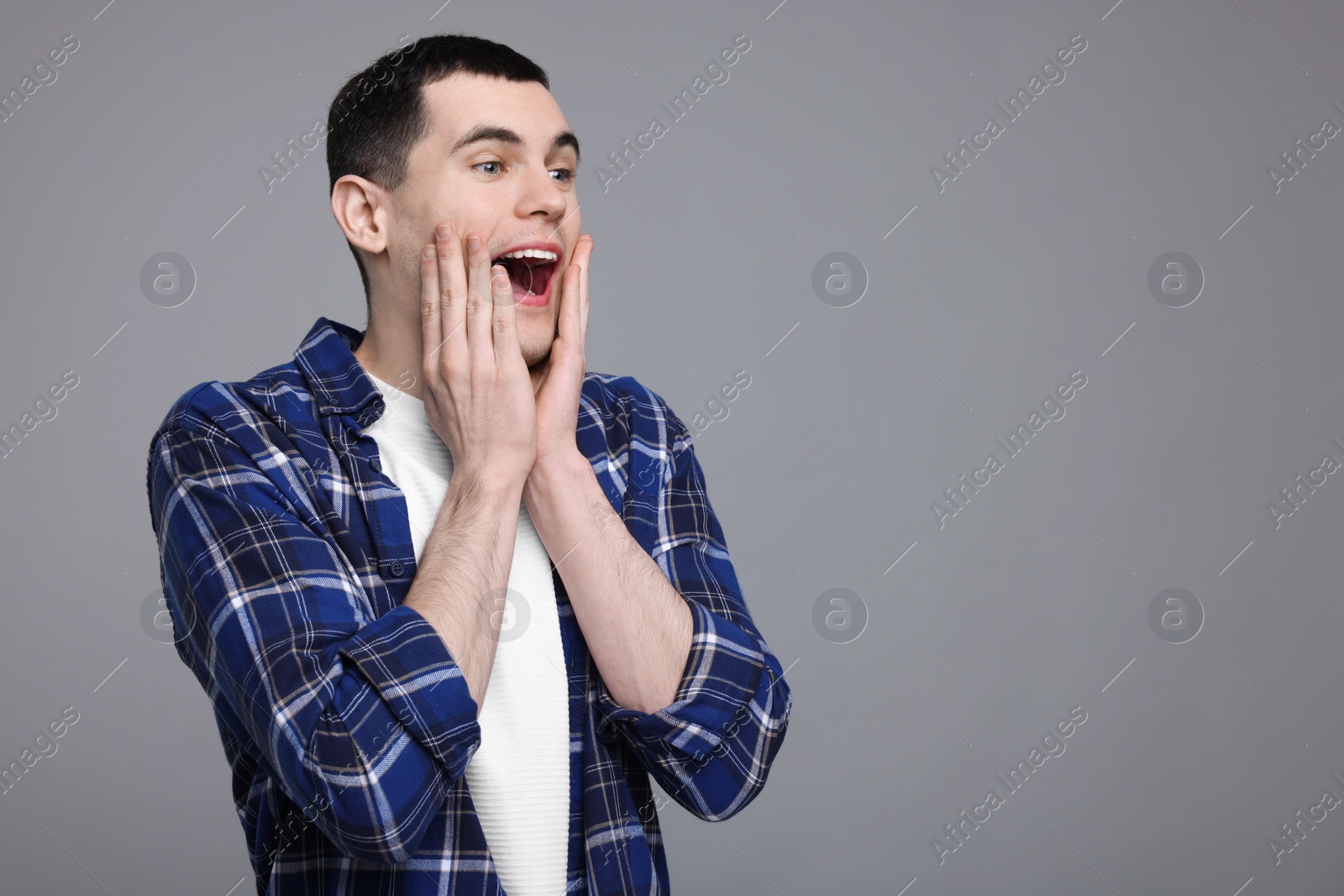 Photo of Portrait of surprised man on grey background, space for text