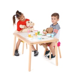 Photo of Little children playing tea party with toys on white background. Indoor entertainment