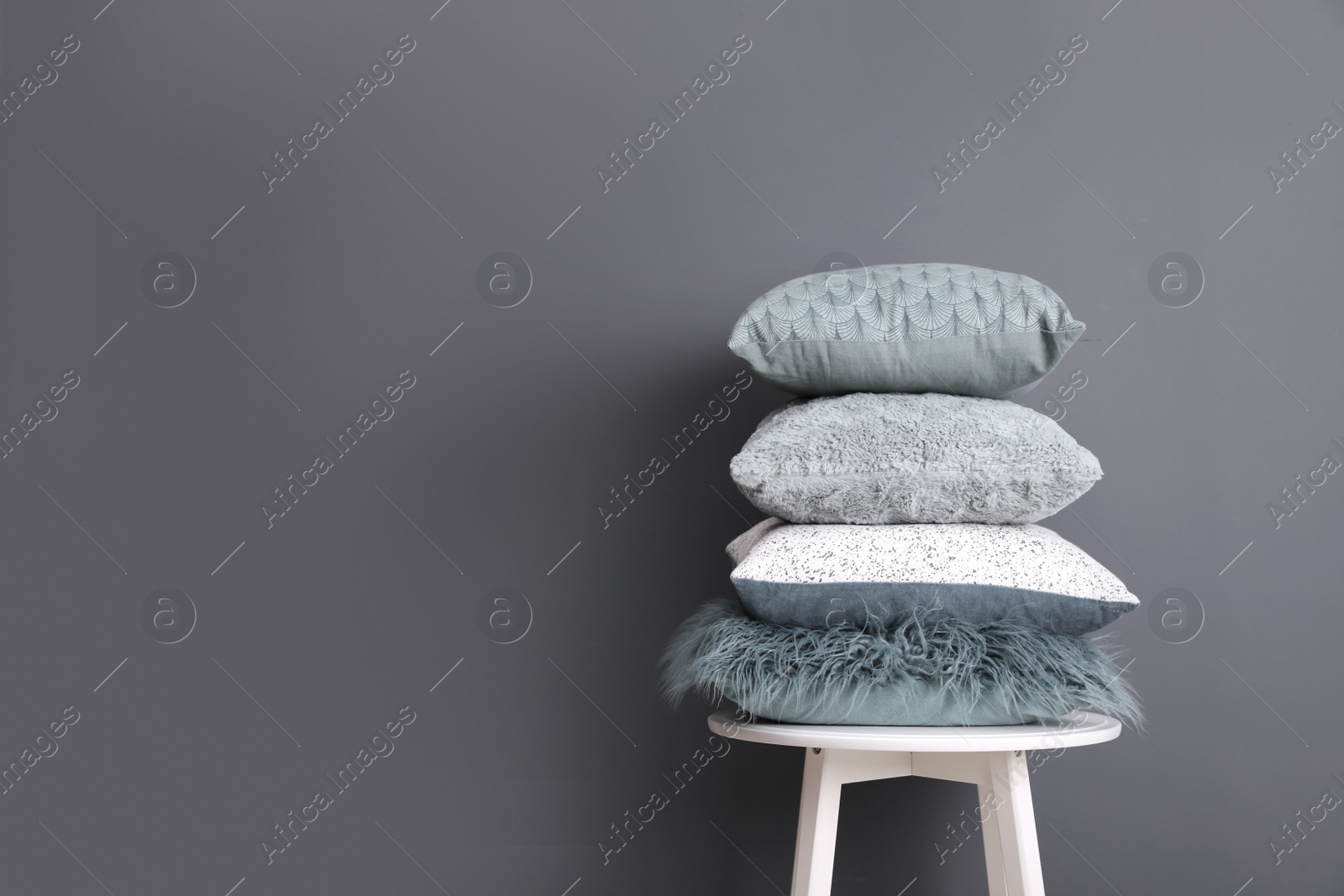 Photo of Chair with many different pillows and space for text on color background