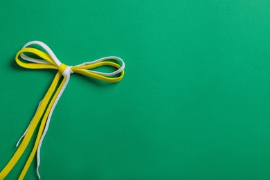 Photo of Shoelaces on green background, top view. Space for text