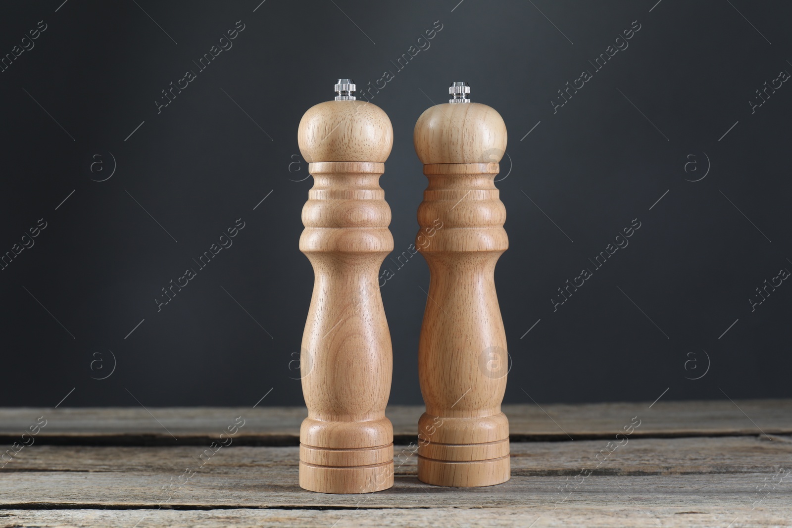 Photo of Salt and pepper shakers on wooden table, closeup