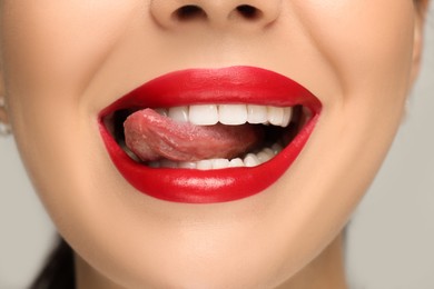 Photo of Woman showing her tongue on light background, closeup
