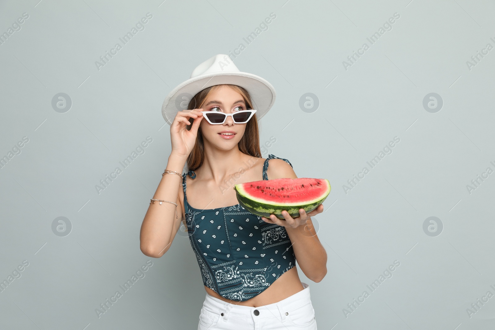 Photo of Beautiful girl with watermelon on grey background