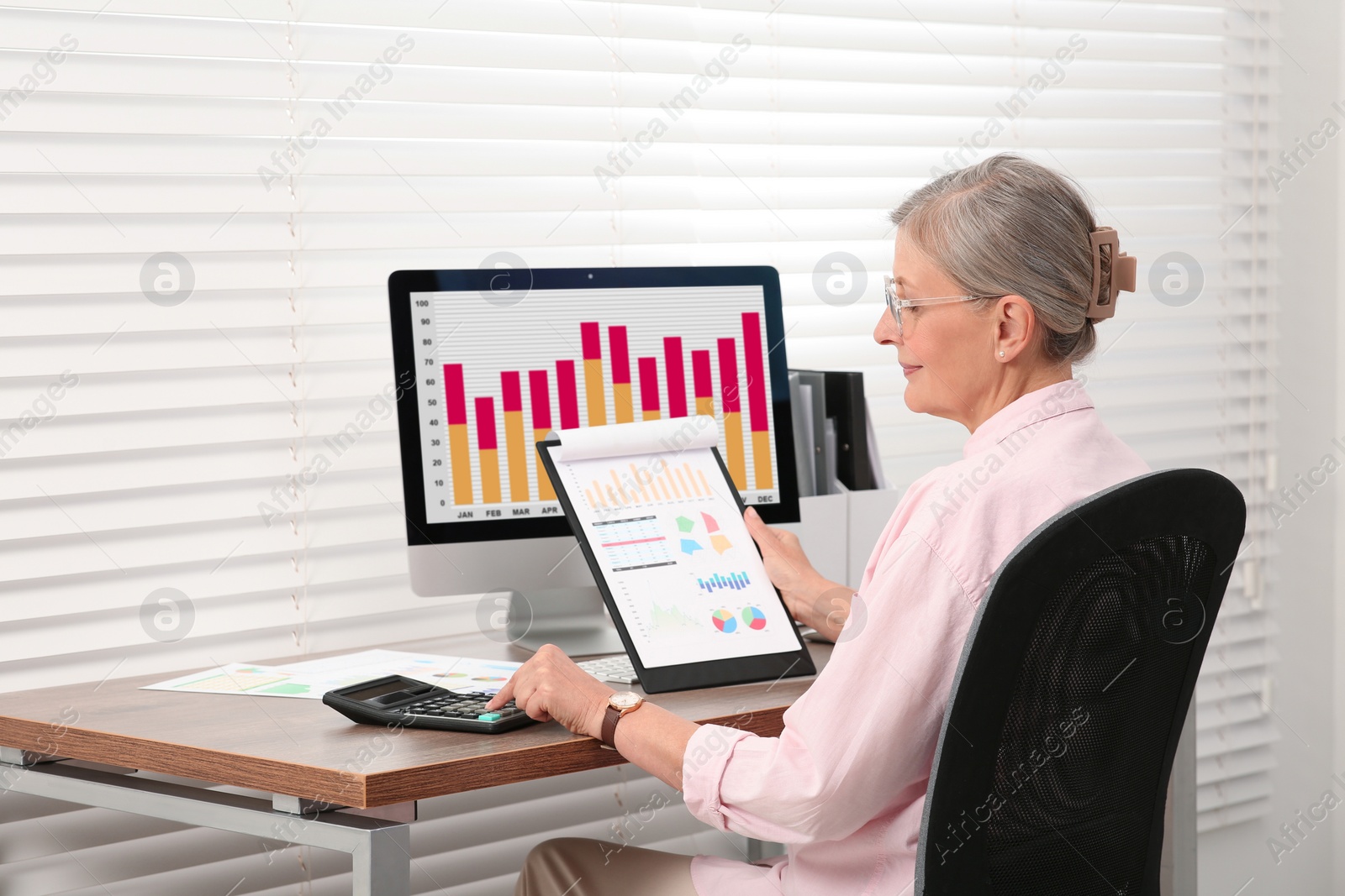 Photo of Senior accountant working at wooden desk in office