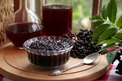 Photo of Elderberry jam and drink with Sambucus berries on table near window