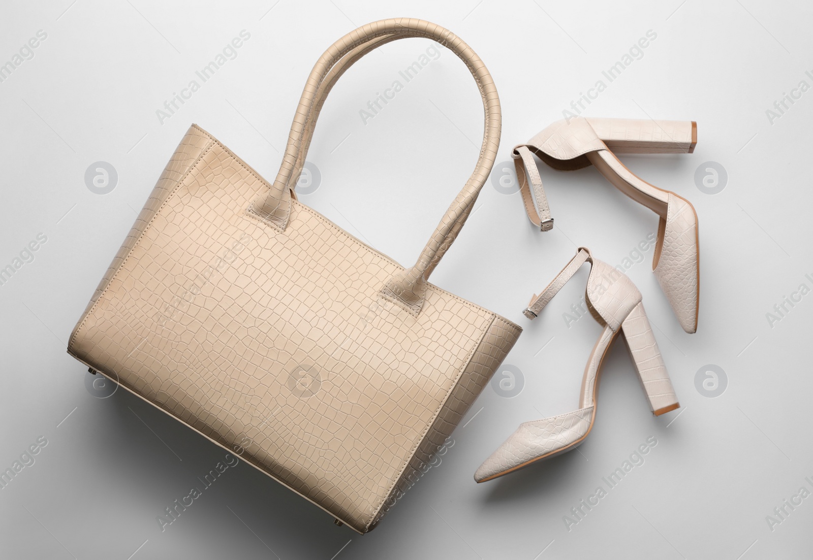 Photo of Stylish woman's bag and shoes on light background, flat lay